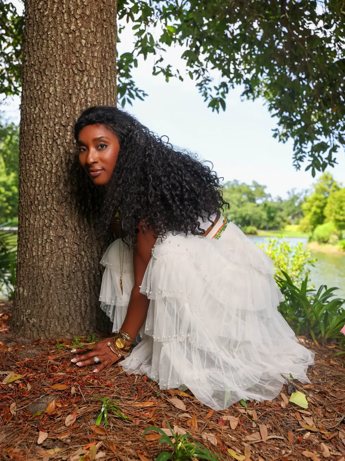Tieara Dokes in an ivory outfit beside a tree