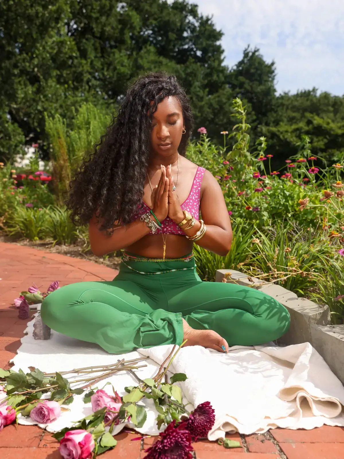 Tieara Dokes seated in a peaceful meditation pose outdoors